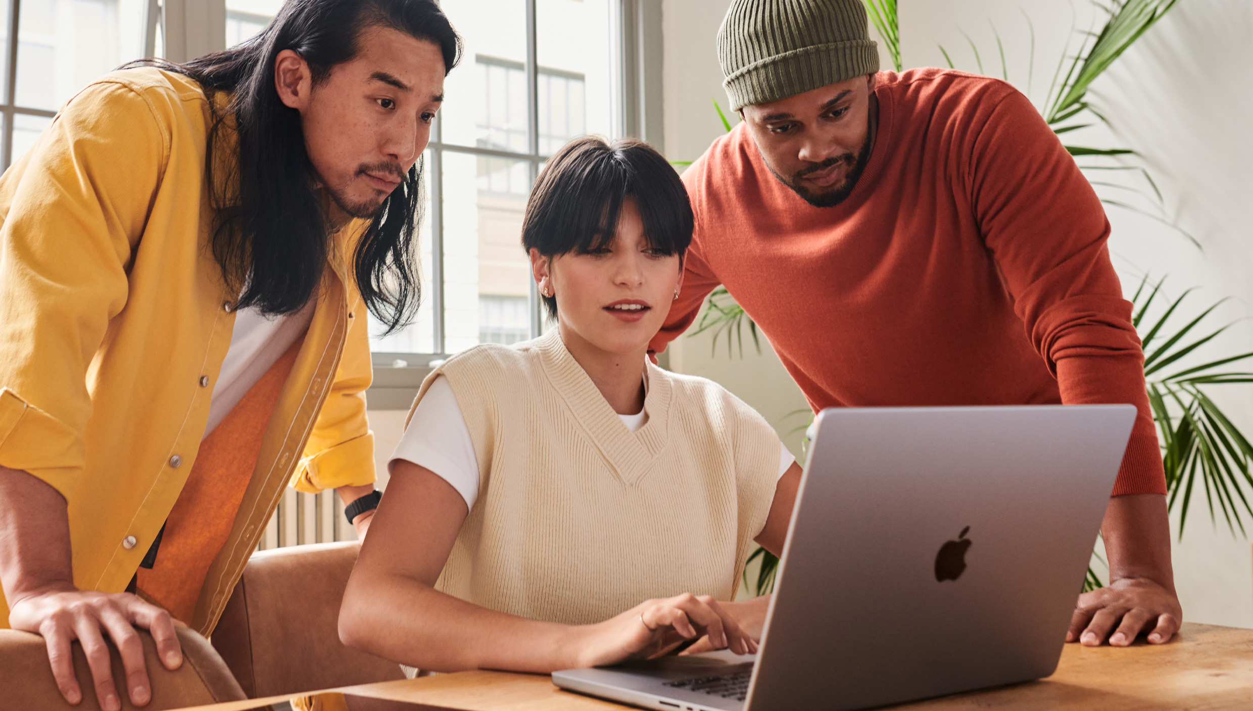 Un team di tre persone che lavorano insieme davanti a un computer.