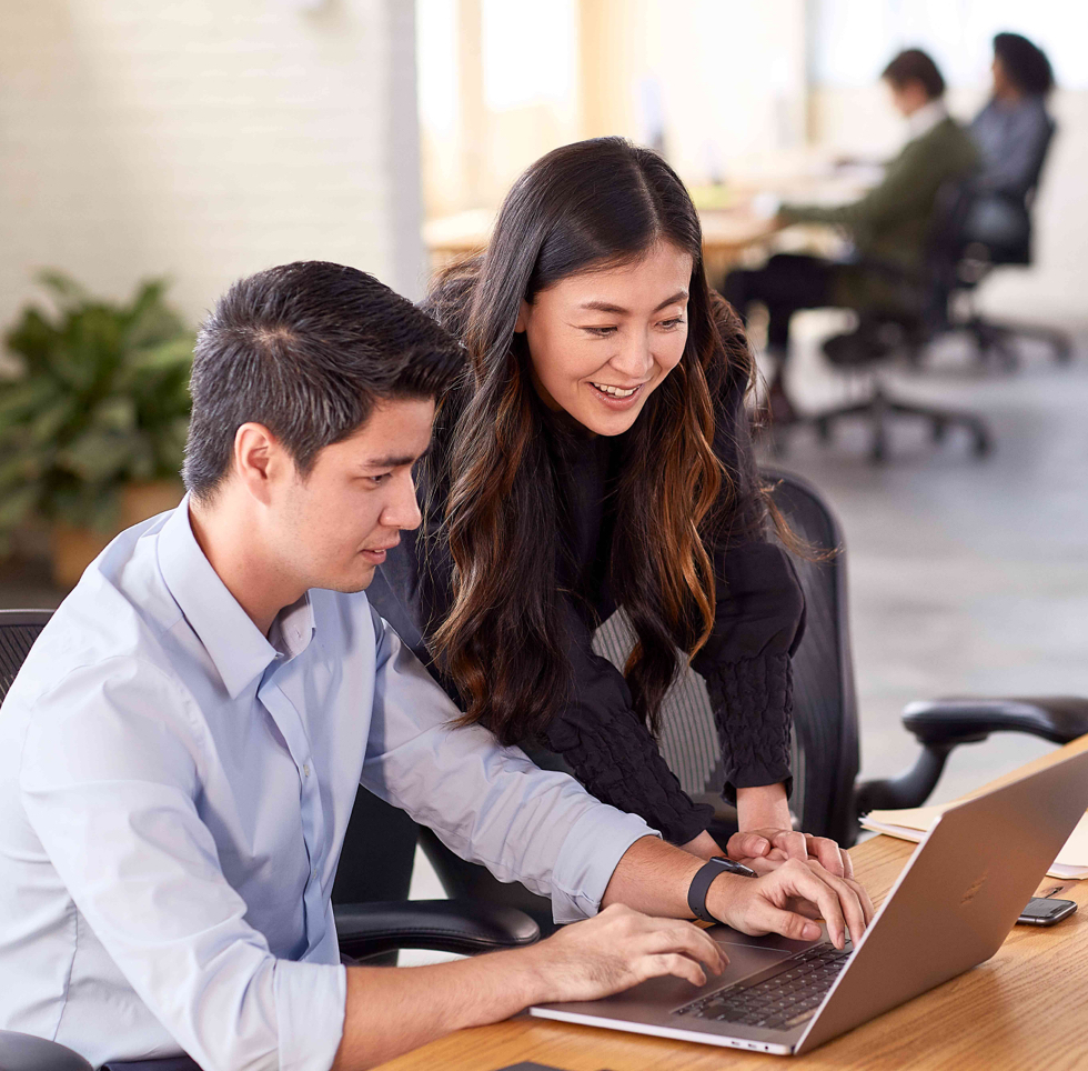 A team of two people working together on a computer.